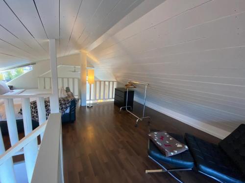 a room with a white wall and a room with a couch at Woodhouse Cottages And Ranch in Prince George