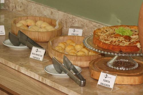 a buffet with several different types of bread and pies at Belaris Hotel in São Luís