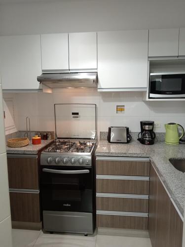 uma cozinha com uma placa de fogão e forno. em Departamento BH South em Lima