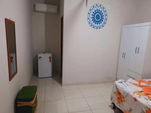 a room with a bed and a small refrigerator at ITAÚNAS Pousada Nossa Palhoça in Itaúnas