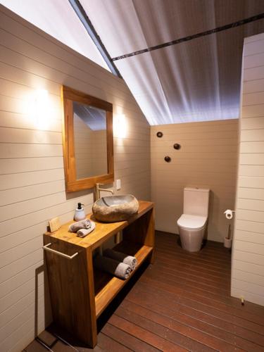 a bathroom with a sink and a mirror and a toilet at Bell Gorge Wilderness Lodge in King Leopold Ranges