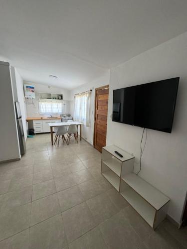 sala de estar con TV de pantalla plana en la pared en Casa dos habitaciones, zona parque en Necochea