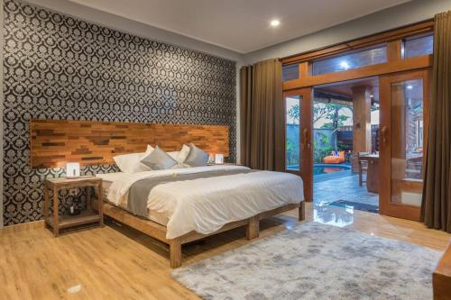 a bedroom with a large bed with a wooden headboard at 2 Bed Beachfront Villa Echo Beach in Canggu