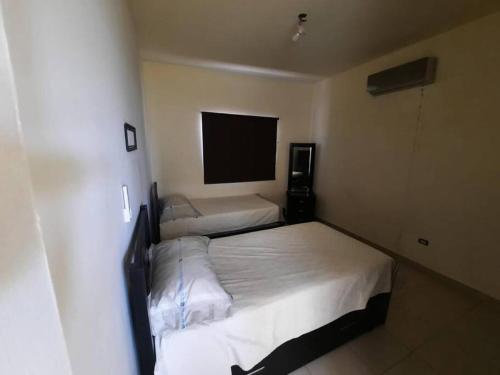 a bedroom with two beds and a flat screen tv at Casa cerca de parque industrial in Monclova