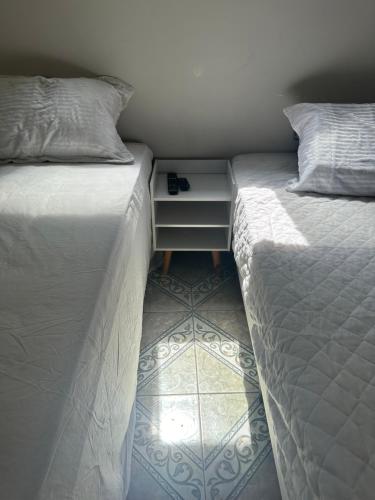 two beds sitting next to each other in a bedroom at Casa alto Vidigal in Rio de Janeiro