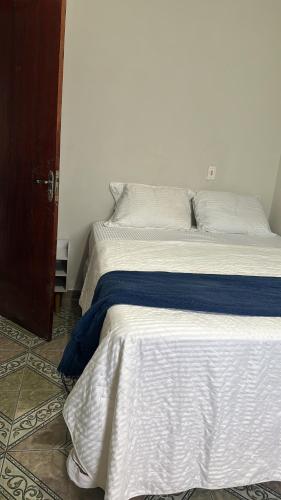 a bed with a blue and white blanket on it at Casa alto Vidigal in Rio de Janeiro