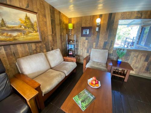 a living room with a couch and a table at Woodhouse Cottages And Ranch in Prince George
