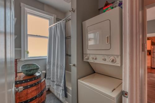 a laundry room with a washer and dryer and a window at Riverfront Steampunk Stunner in Midtown Harrisburg near Hershey Attractions in Harrisburg