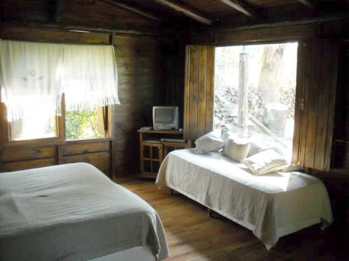 a bedroom with two beds and a window at Cabañas Las Lavandas en Pilar in Pilar