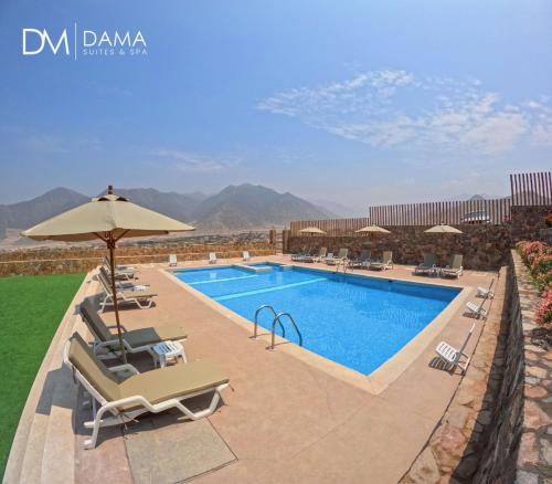 a swimming pool with lounge chairs and an umbrella at Dama Suites & Spa in Cieneguilla