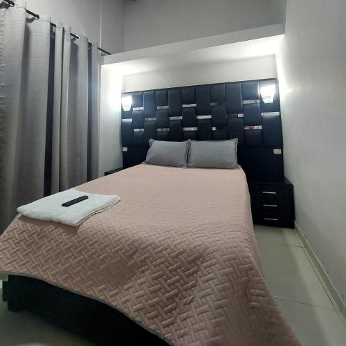 1 dormitorio con 1 cama grande y cabecero negro en VIVENTO Habitaciones lujosas estrato 6 frente a CC Campanario en Popayán