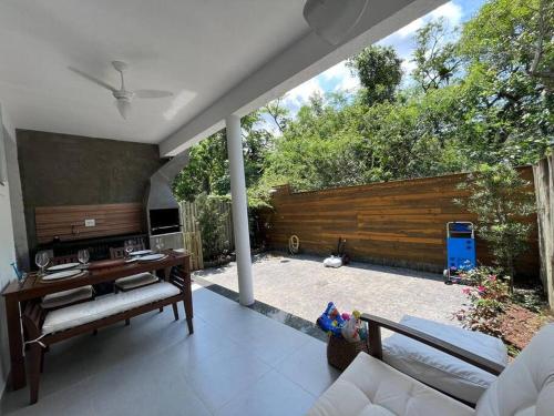a living room with a couch and a table and a fence at Casa completa cond. fechado em Paúba, S. Sebastião in São Sebastião