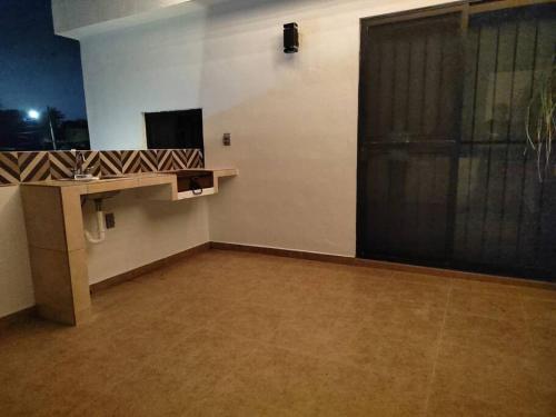 an empty room with a table and a window and a screen at Depa independiente con Terraza Super ubicado . in Ciudad Madero