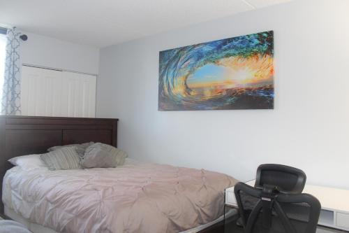 sypialnia z łóżkiem, krzesłem i obrazem w obiekcie Renovated Bright & Spacious Royal Kuhio Studio condo w mieście Honolulu