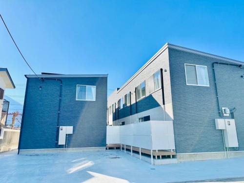 a blue brick building with windows on a street at Megu Fuji Plus in Fujiyoshida