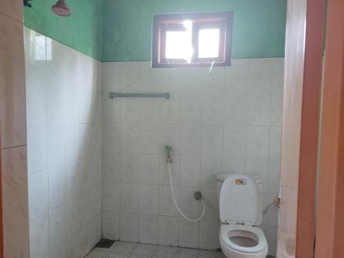 a bathroom with a toilet and a window at Green Waves HomeStay in Nonagegama