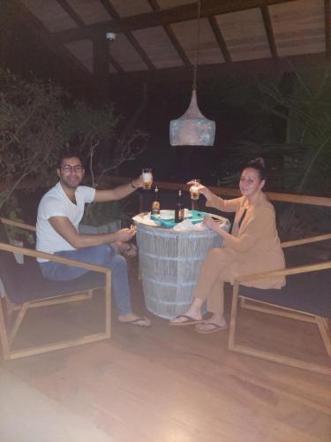 a man and a woman sitting at a table with drinks at Paradise Itzu in Kandy