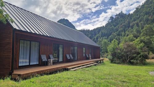 ein Gebäude mit Fenstern an der Seite eines Feldes in der Unterkunft Refugio Río Roberto in Villa Santa Lucía