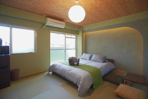 - une chambre avec un lit et une grande fenêtre dans l'établissement 抹茶庵世田谷東京 Matcha-An Setagaya Tokyo, à Tokyo
