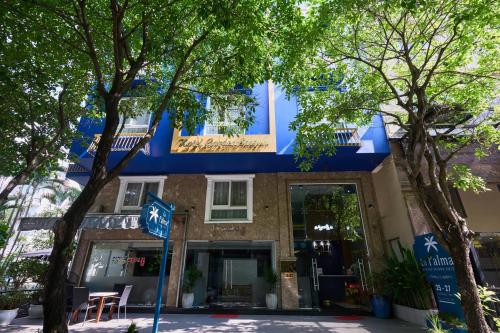 a blue building with trees in front of it at La Palma Boutique Hotel in Ho Chi Minh City