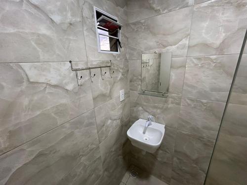 La salle de bains est pourvue d'un lavabo et d'un miroir. dans l'établissement Suites Mar Azul, à São José da Coroa Grande