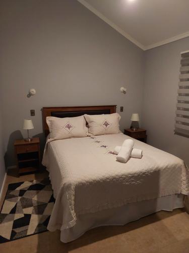 a bedroom with a large white bed with two night stands at Casa Isabella in Puerto Natales