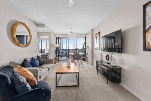 a living room with a couch and a table at Top Floor! 2Bed/2Bath/1Car/Pool ~ VIEWS ~ CBD in Brisbane