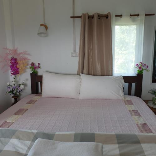 1 cama con almohadas blancas en una habitación con ventana en สวนมรดกดอย 