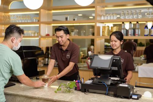 a group of people standing at a counter in a restaurant at Mansion 51 Hotel & Apartment in Phnom Penh