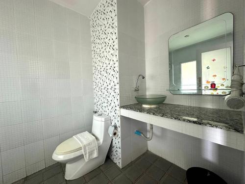 a bathroom with a toilet and a sink and a mirror at Anantra Pattaya Resort in Pattaya Central