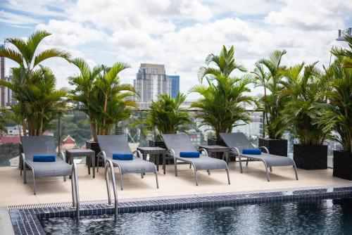 a hotel patio with chairs and a swimming pool at Mansion 51 Hotel & Apartment in Phnom Penh