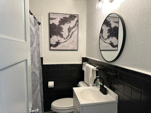 een badkamer met een toilet, een wastafel en een spiegel bij Cozy & Modern Oasis Retreat I Pets Allowed Lilac1 in Midwest City