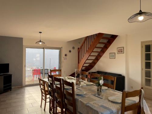 une salle à manger avec une table et un escalier dans l'établissement Maison familiale spacieuse, 5 chambres, à 350m de la plage des Demoiselles, calme et confort - FR-1-323-489, à Saint-Hilaire-de-Riez