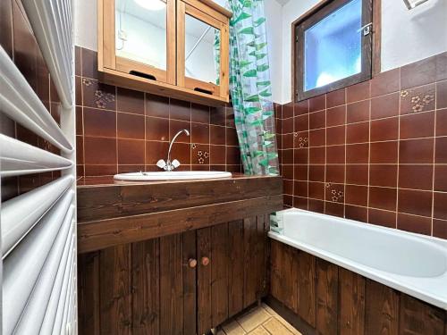 une salle de bain avec un lavabo et une baignoire dans l'établissement Studio au Monêtier-les-Bains avec balcon, parking et proche des pistes pour 4 personnes - FR-1-330F-228, au Monêtier-les-Bains