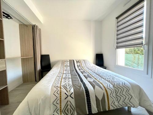 un letto in una stanza con una finestra di Maison familiale récente avec jardin, plage et commerces à pied, 6 couchages, WIFI, parking privatif - FR-1-231-297 a Brem-sur-Mer