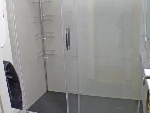 une douche avec une porte vitrée dans une salle de bain dans l'établissement Charmant 3 pièces avec piscines, parking et animaux acceptés - FR-1-629-137, à Samoëns