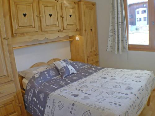 une chambre avec un lit et une armoire en bois dans l'établissement Charmant 3 pièces avec piscines, parking et animaux acceptés - FR-1-629-137, à Samoëns