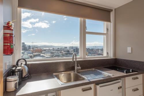 a kitchen with a sink and a large window at Capital View Motor Inn in Wellington