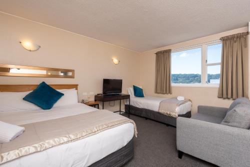 Habitación de hotel con 2 camas y sofá en Capital View Motor Inn en Wellington