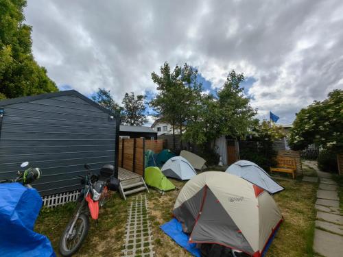 een groep tenten en een motorfiets geparkeerd in een tuin bij Alojamiento Emilia House in Punta Arenas