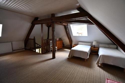 a attic room with two beds and a window at Le Clos du Petit Dannezy in Cour-Cheverny