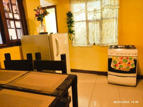 cocina con nevera, mesa y fogones en Casas vacacionales Baños, en Baños