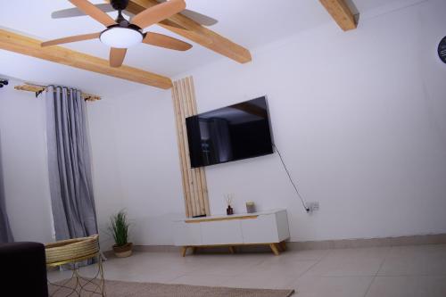 uma sala de estar com uma televisão de ecrã plano na parede em Kanana Villas em Otse