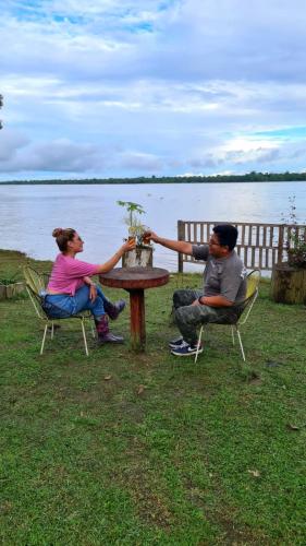 a man and woman sitting around a table with a plant at Milía Amazon Lodge in Iquitos