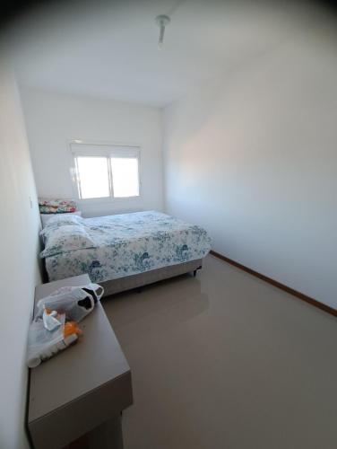 1 dormitorio con cama, mesa y ventana en Incrível Vista Panorâmica, en Tramandaí