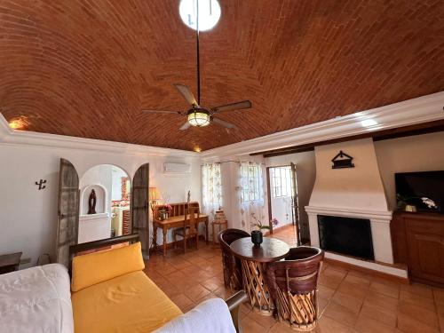 a living room with a ceiling fan and a table at Casa Mona Lisa, a short, level walk to the cathedral in San Miguel de Allende