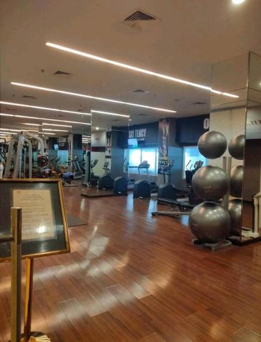 a gym with a wooden floor and exercise equipment at Orchard Apartment Pakuwon Mansion 2 by Shinzhouz in Surabaya