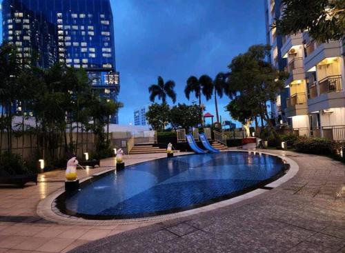 uma piscina com escorrega numa cidade em Orchard Apartment Pakuwon Mansion 2 by Shinzhouz em Surabaya