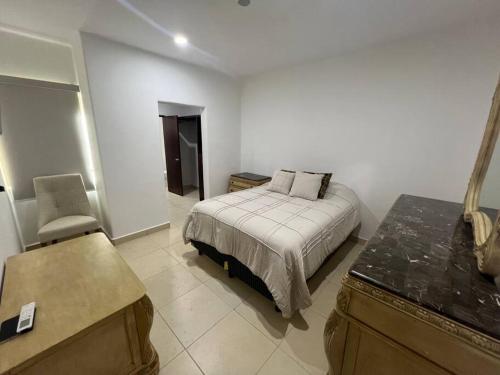 a bedroom with a bed and a desk and a chair at Casa Portobello in La Paz