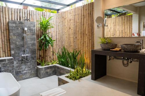 a bathroom with a shower and plants at Pax Ana Doc Let Resort & Spa in Ninh Hòa